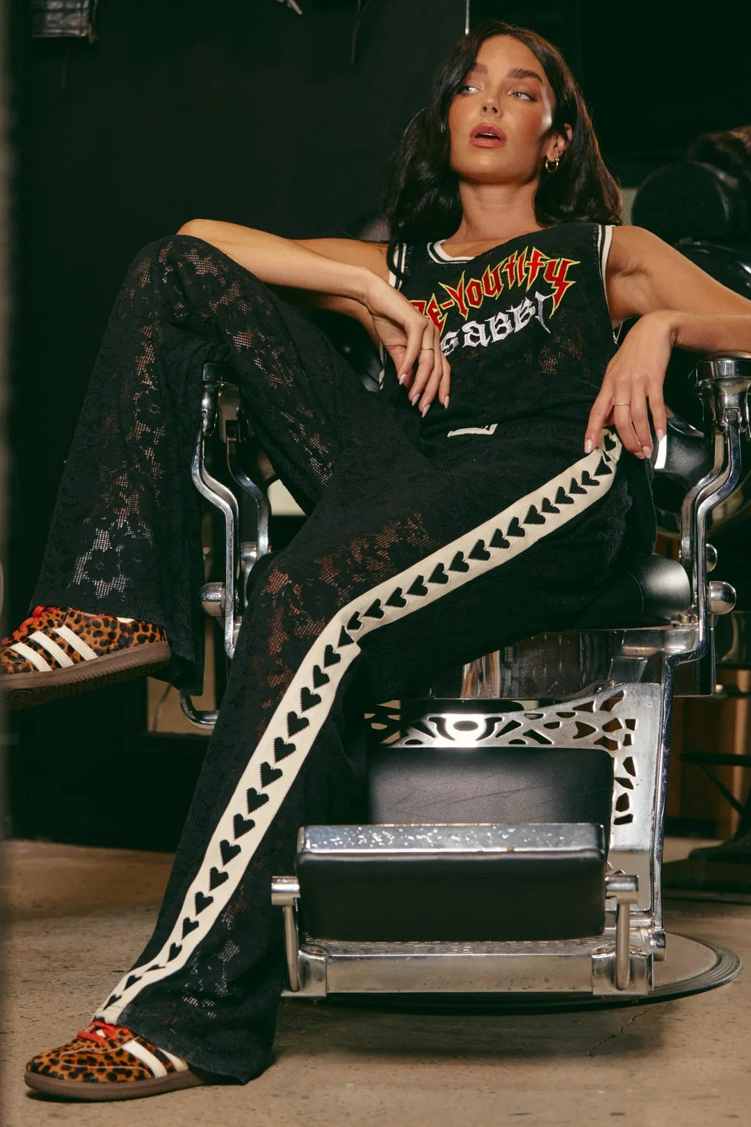 Woman wearing sabbi raving hearts lace pants. Black pants with hearts down the sides.