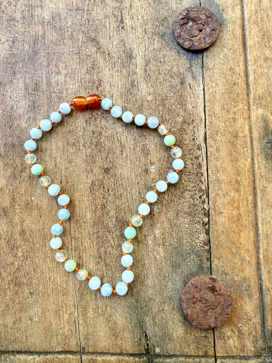 Aquamarine, fluorite and amazonite necklace on weathered wood