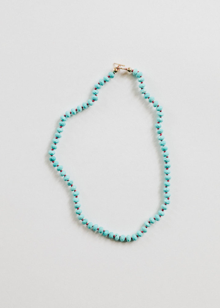Turquoise gemstone necklace with gold filled toggle laid flat