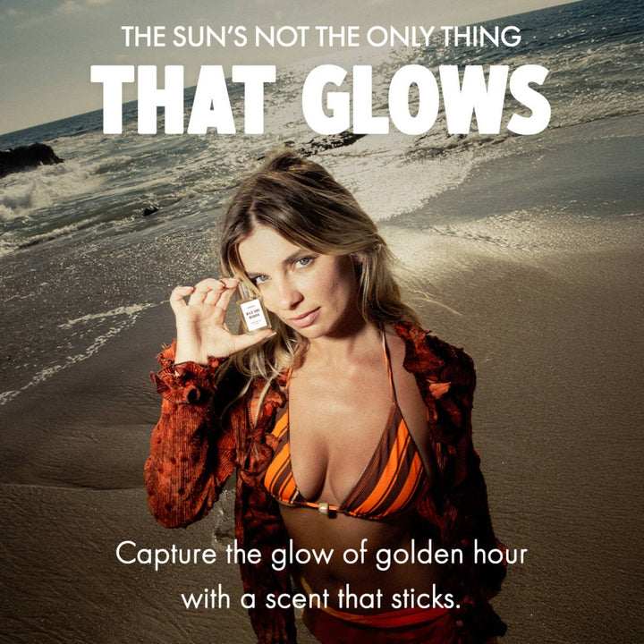 Woman on the beach at golden hour holding Wild and Woman perfume oil