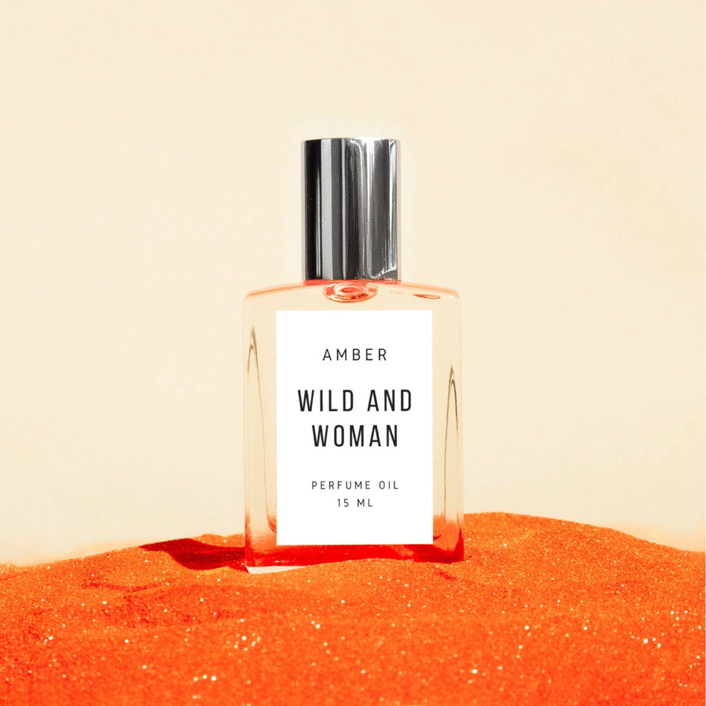 Amber perfume oil 15 ml glass rollerball on orange sand