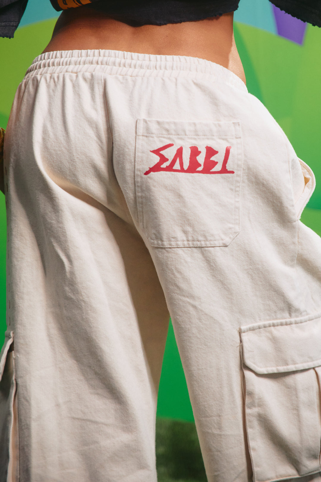 Close-up detail of the cargo pocket graphics on the cream jorts