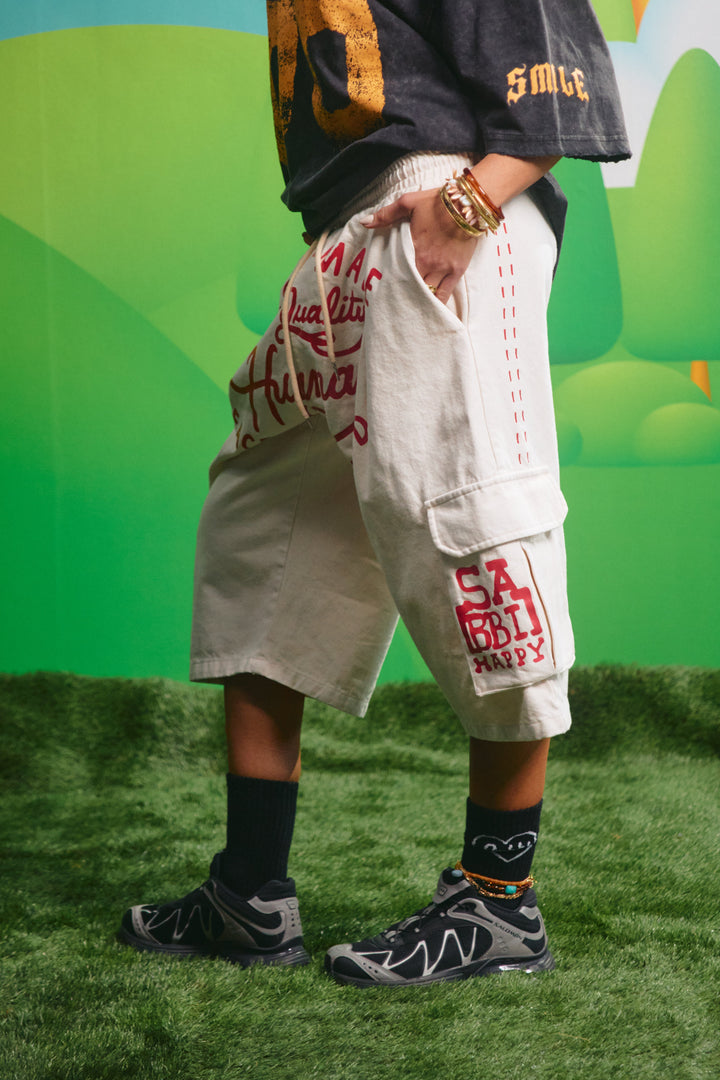 Side view of the oversized cream cargo jorts showing the relaxed fit