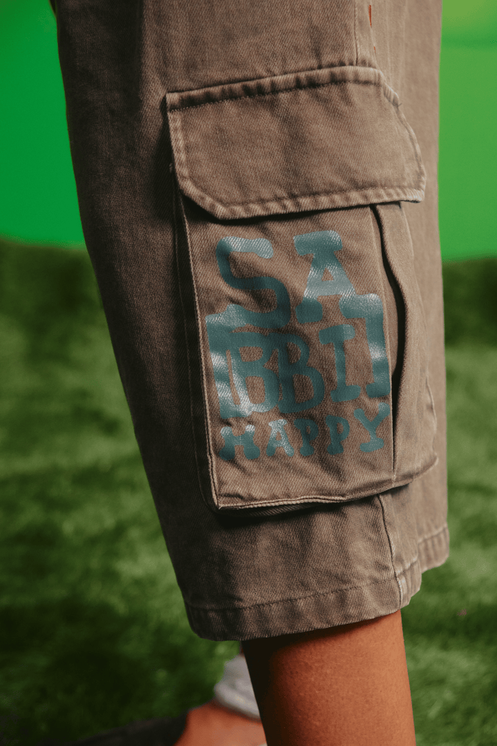 Close-up detail of the faded blue graphic on the khaki cargo jorts