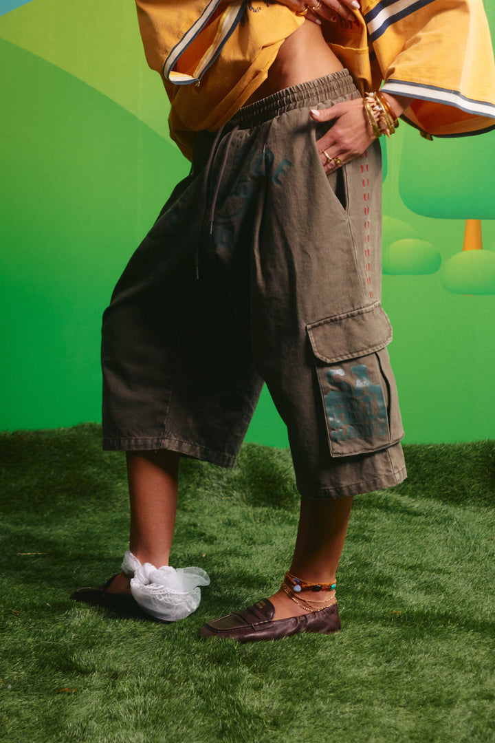 Side view of the oversized khaki cargo jorts showing the relaxed fit