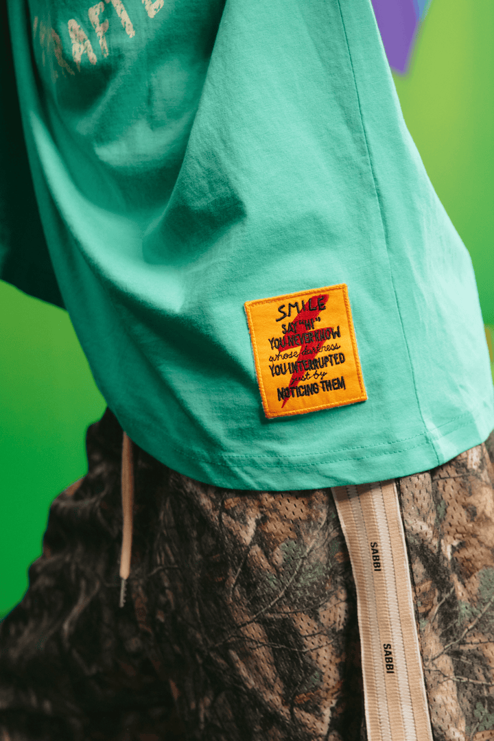 Close-up detail of the shoulder graphic on the green tee