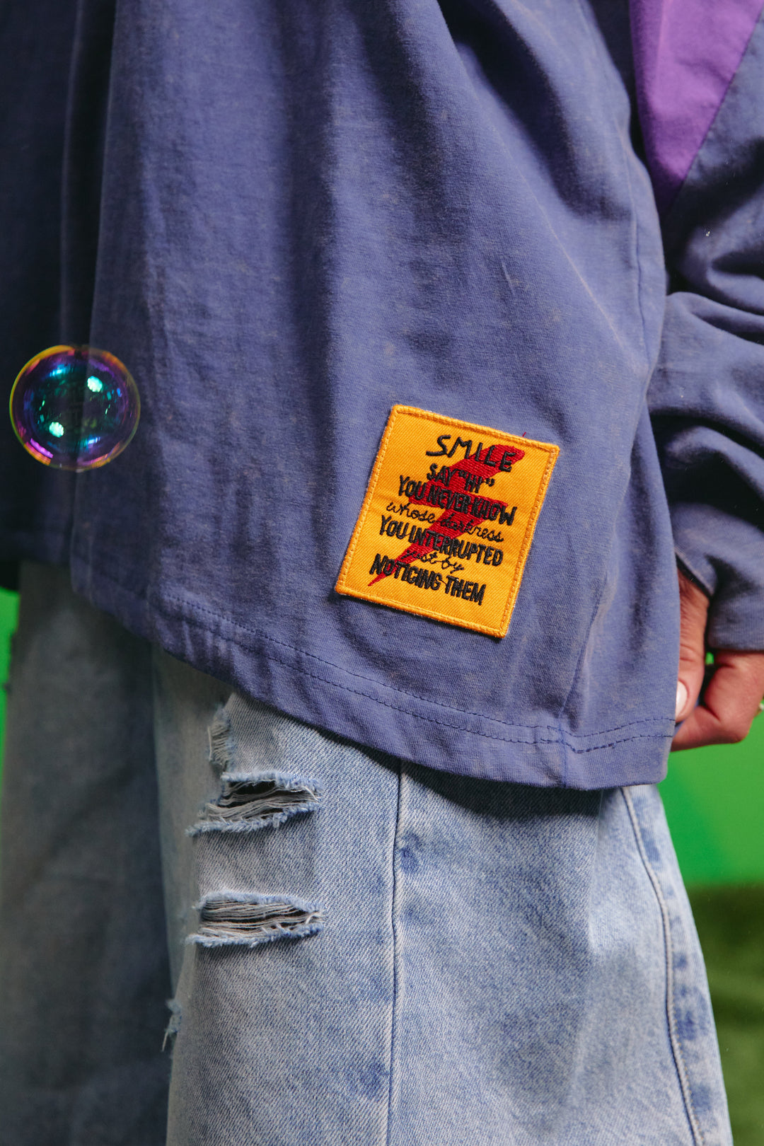 Close-up detail of the front graphic on the purple tee