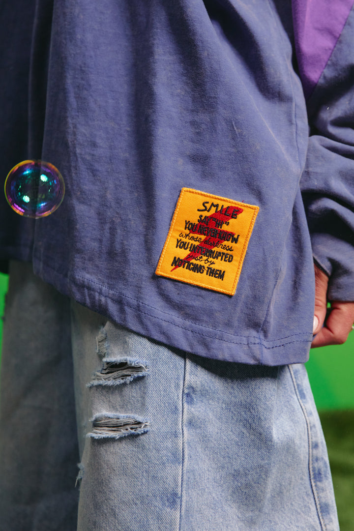 Close-up detail of the front graphic on the purple tee