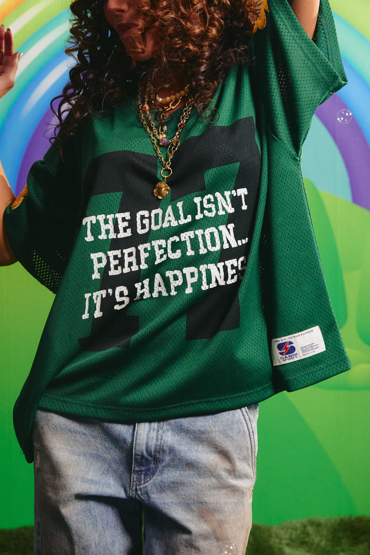 Close-up detail of the fuzzy yellow Sabbi sleeve lettering on the green mesh tee