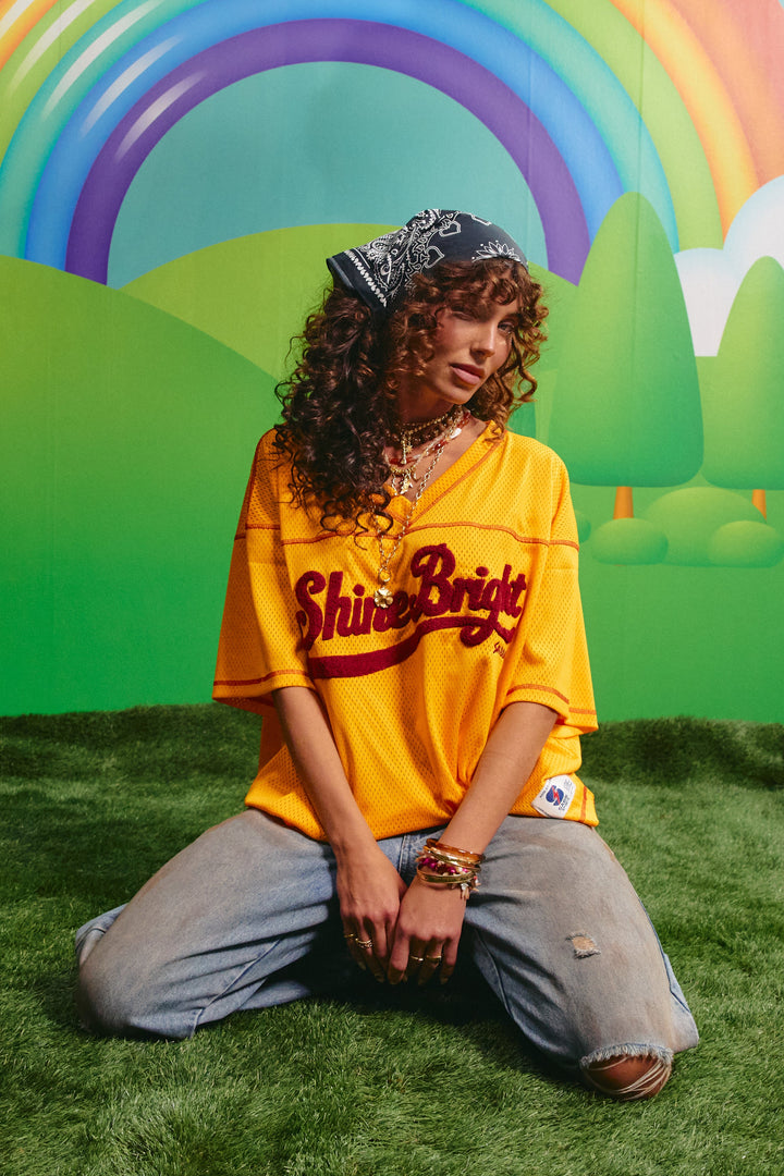 Model wearing the yellow Sabbi Shine Bright mesh tee styled with denim