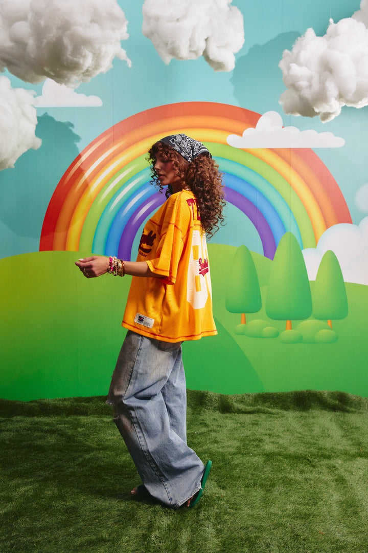 Side view of the oversized yellow mesh tee showing the relaxed fit