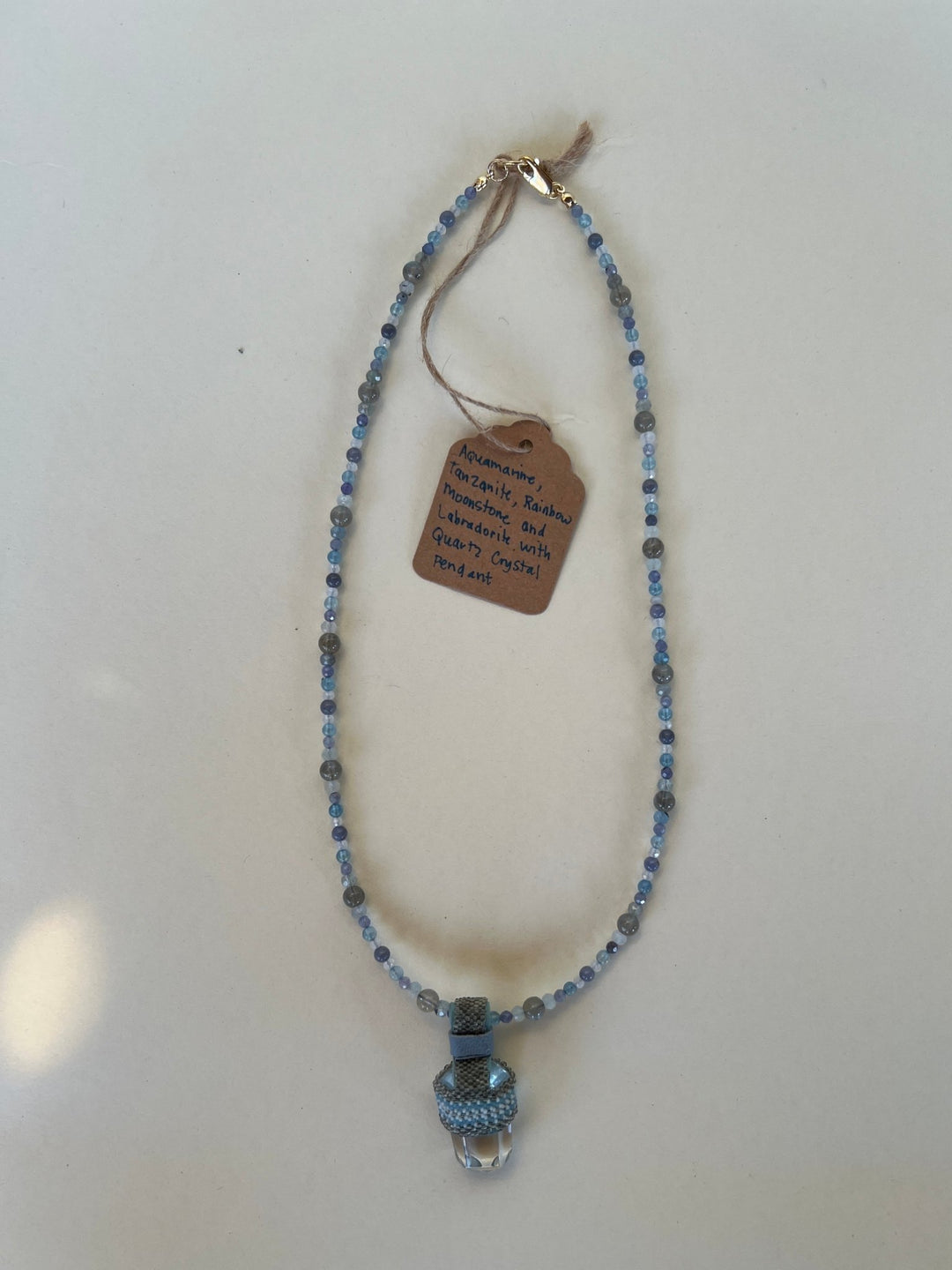 Necklace with blue beads and a tag on a white background