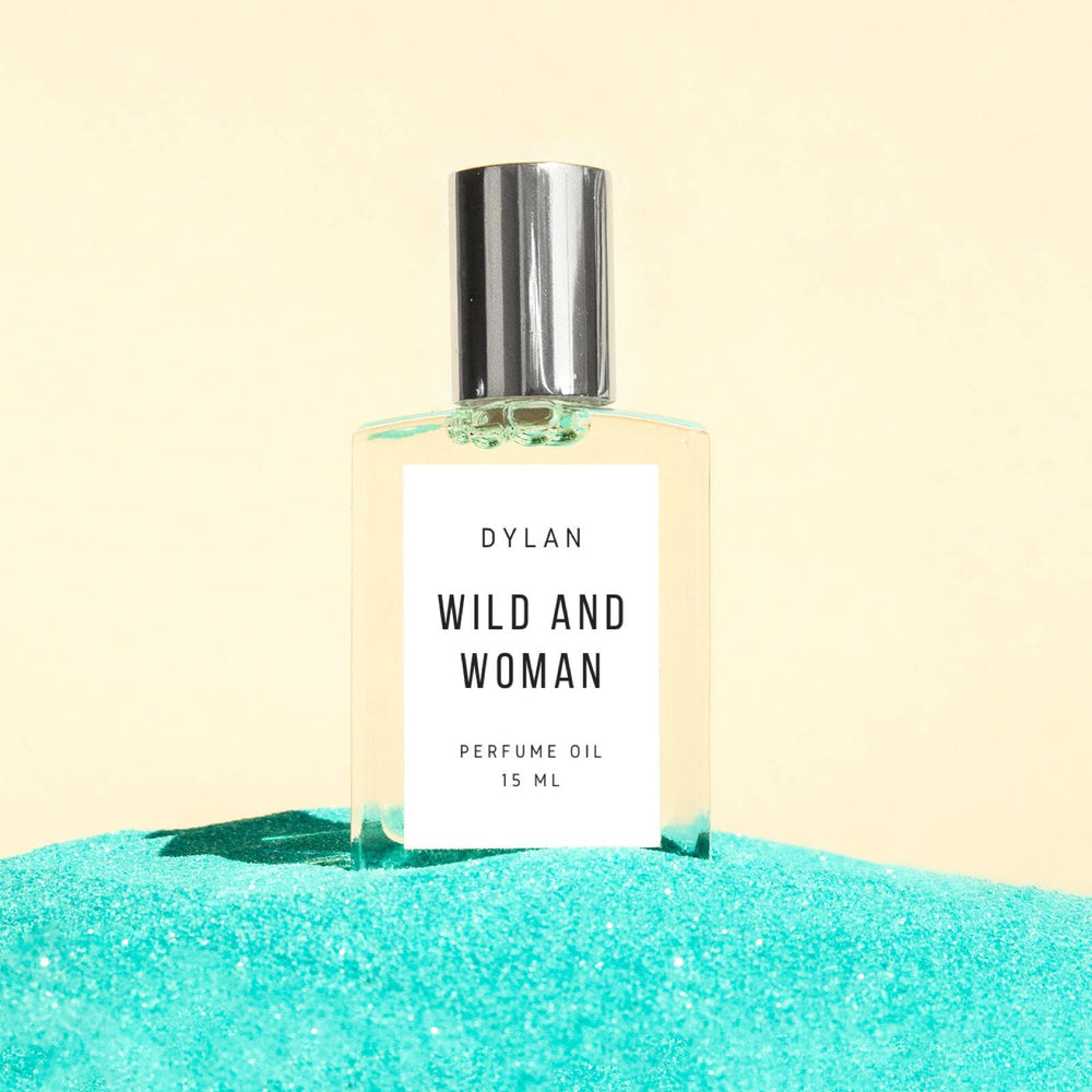 Perfume oil bottle labeled 'Wild and Woman' by Dylan on a turquoise and beige background