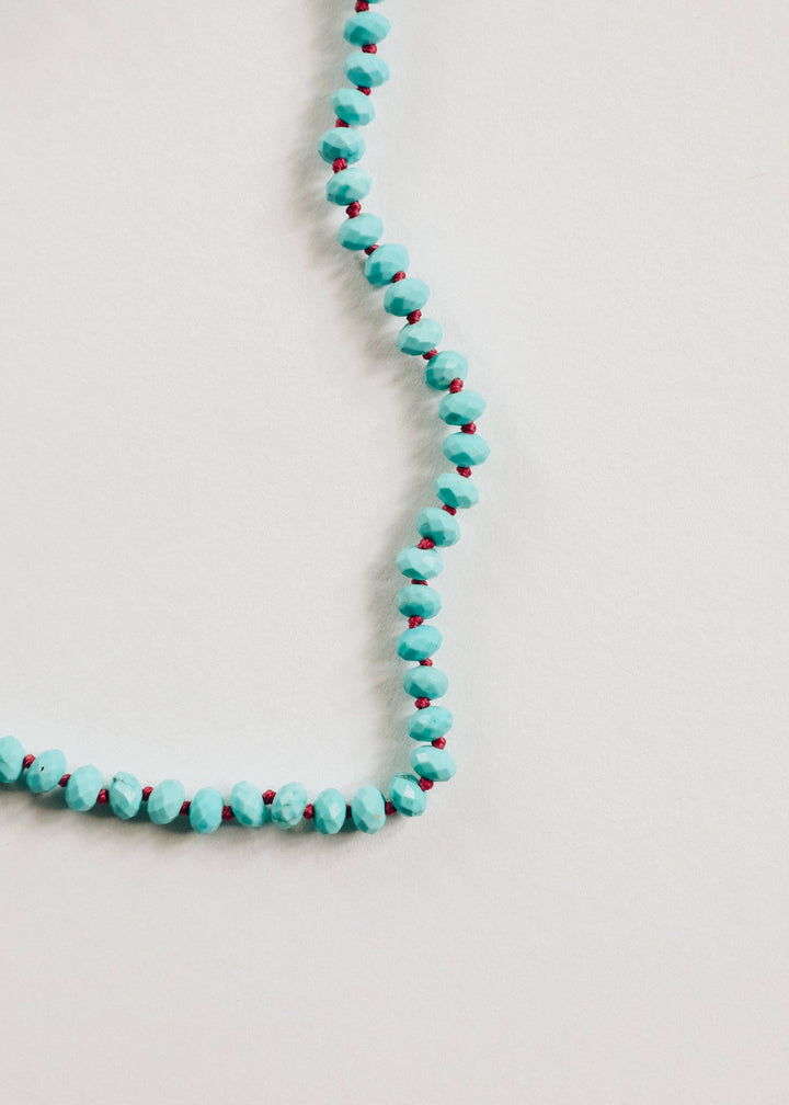 Close up of turquoise beads hand knotted on pink cord