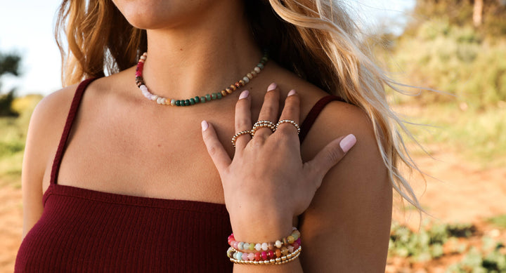 Woman wearing a CanyonLeaf gemstone necklace with stacked bracelets