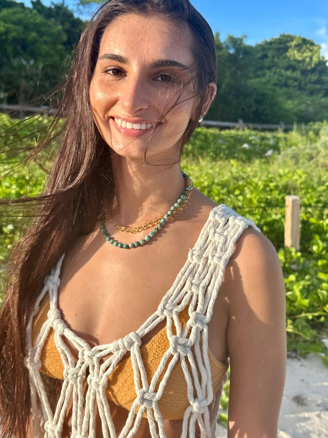Woman on the beach wearing a gemstone necklace
