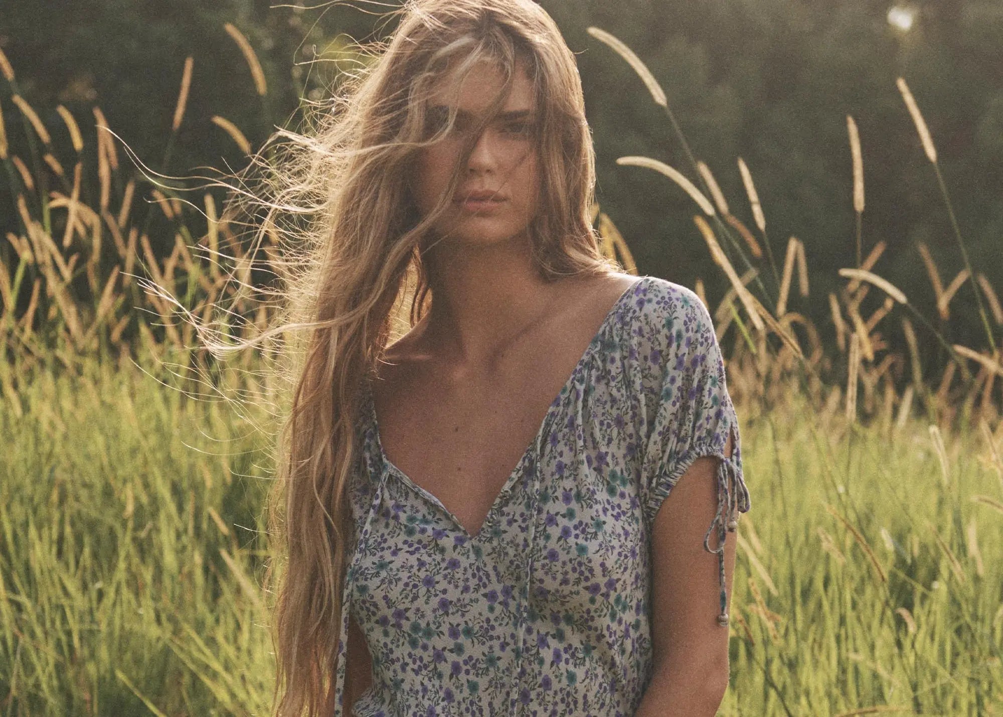 Woman with long blonde hair standing in a field of tall grass