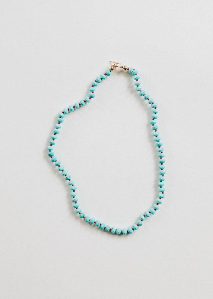 Turquoise gemstone necklace with gold filled toggle laid flat